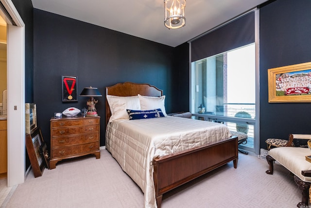 bedroom featuring light carpet and an inviting chandelier
