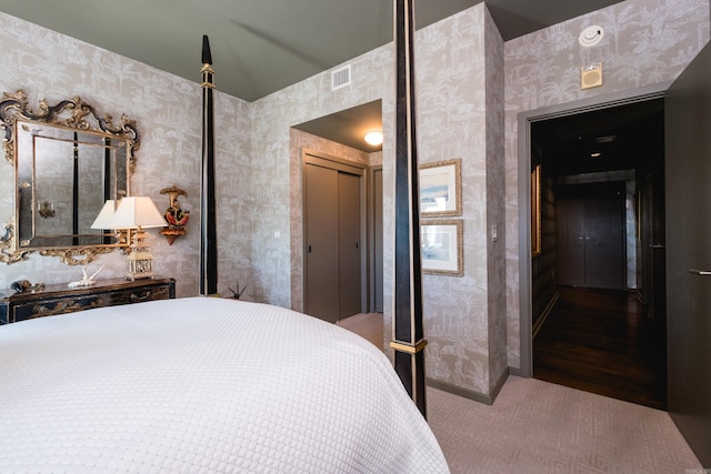 carpeted bedroom featuring wallpapered walls, baseboards, and visible vents