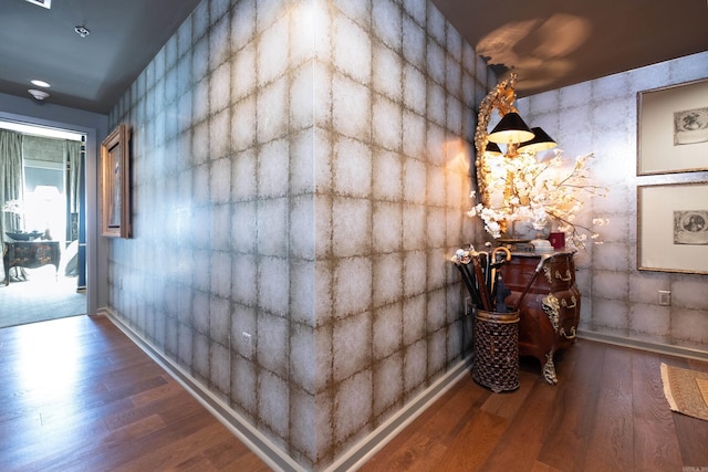 corridor featuring an inviting chandelier and wood finished floors