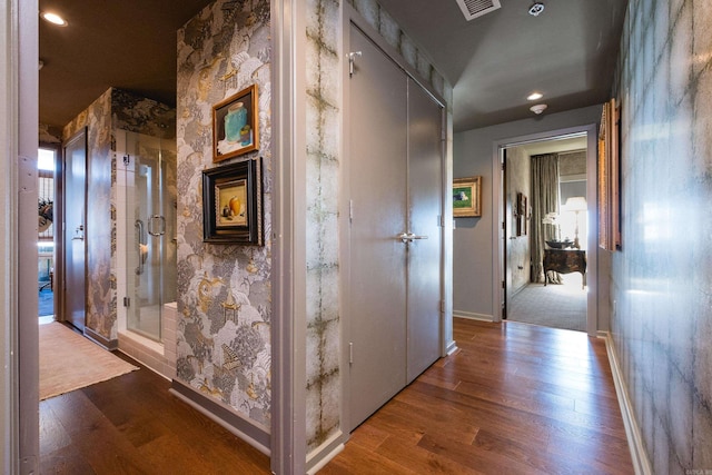 corridor with visible vents, baseboards, and wood finished floors