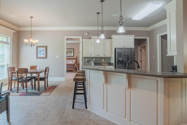kitchen featuring crown molding, backsplash, visible vents, and stainless steel refrigerator with ice dispenser