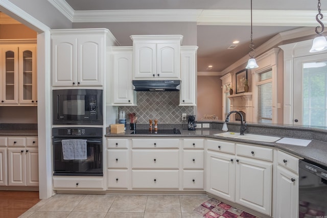 kitchen with crown molding, tasteful backsplash, black appliances, under cabinet range hood, and a sink