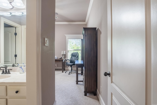 hall with light carpet, baseboards, a sink, and ornamental molding