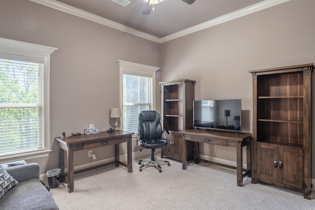 carpeted home office with a healthy amount of sunlight, ornamental molding, baseboards, and a ceiling fan