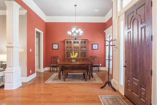 dining room with a notable chandelier, light wood-style flooring, ornamental molding, and a healthy amount of sunlight