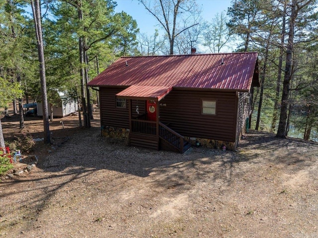 exterior space featuring log veneer siding and metal roof