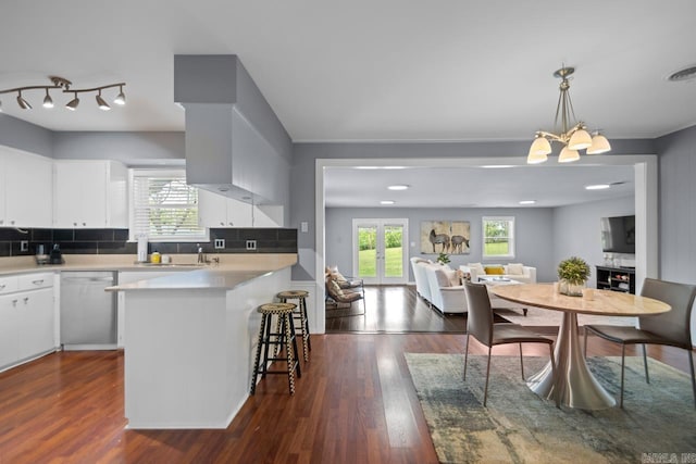 6808 Sandpiper Dr, Little Rock, AR 72205 - kitchen featuring an inviting chandelier, open floor plan, a peninsula, a breakfast bar area, and dishwashing machine