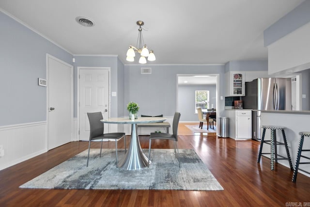 6808 Sandpiper Dr, Little Rock, AR 72205 - dining room featuring crown molding, visible vents, a notable chandelier, and dark wood finished floors