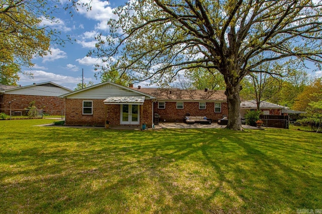 6808 Sandpiper Dr, Little Rock, AR 72205 - back of property featuring a patio area, a lawn, fence, brick siding, and french doors