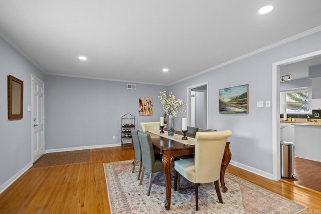 6808 Sandpiper Dr, Little Rock, AR 72205 - dining space with light wood-type flooring, crown molding, visible vents, and recessed lighting