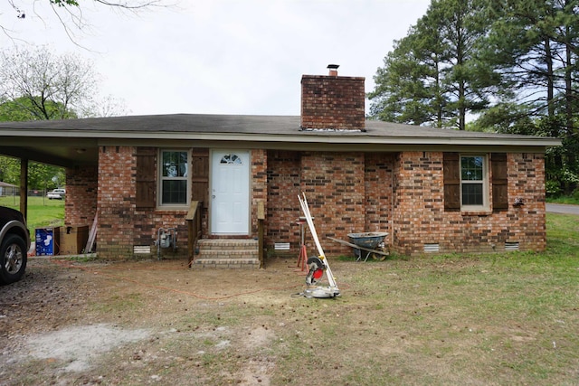 view of front of house featuring crawl space, a chimney, entry steps, and brick siding