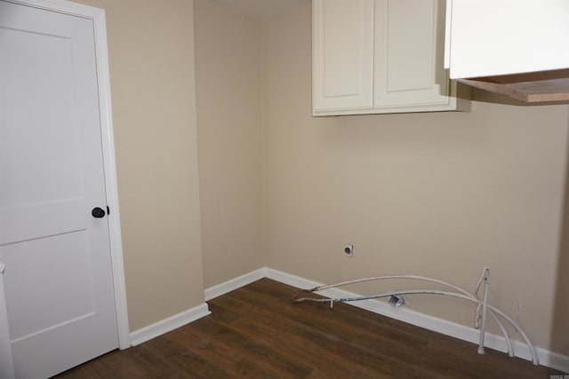 clothes washing area with cabinet space, baseboards, and dark wood-style flooring