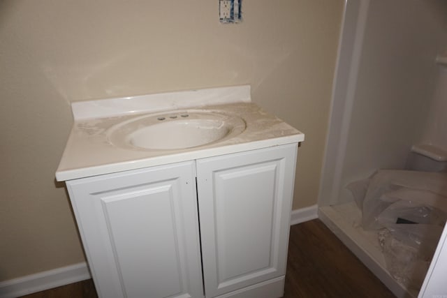 bathroom featuring baseboards, vanity, and wood finished floors