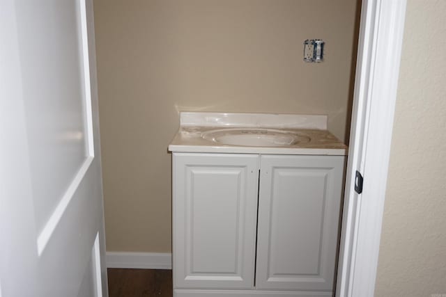 bathroom with baseboards, vanity, and wood finished floors