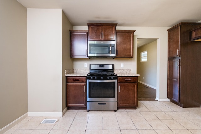 6 Broadmoor Dr, Little Rock, AR 72204 - kitchen featuring light tile patterned floors, dark brown cabinets, visible vents, stainless steel appliances, and baseboards