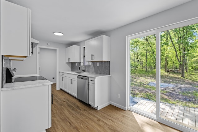 kitchen featuring baseboards, backsplash, dishwasher, a sink, and electric range oven