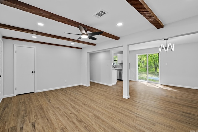 unfurnished living room with ceiling fan with notable chandelier, visible vents, recessed lighting, light wood finished floors, and beam ceiling