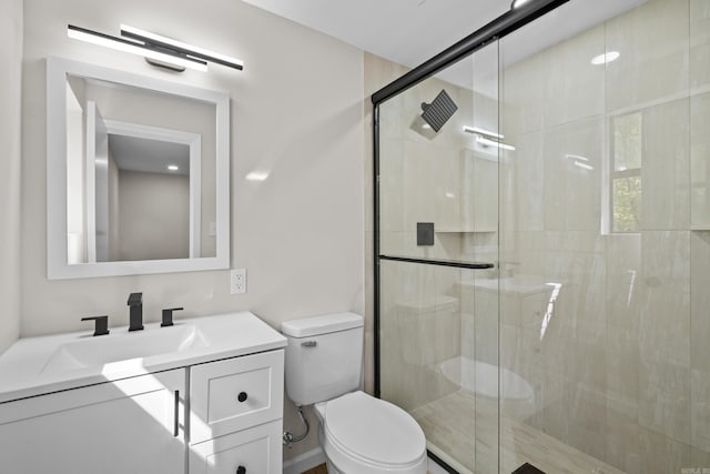 bathroom featuring toilet, vanity, and a shower stall
