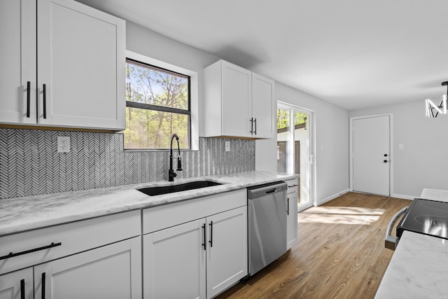 kitchen featuring white cabinets, a sink, wood finished floors, backsplash, and stainless steel dishwasher
