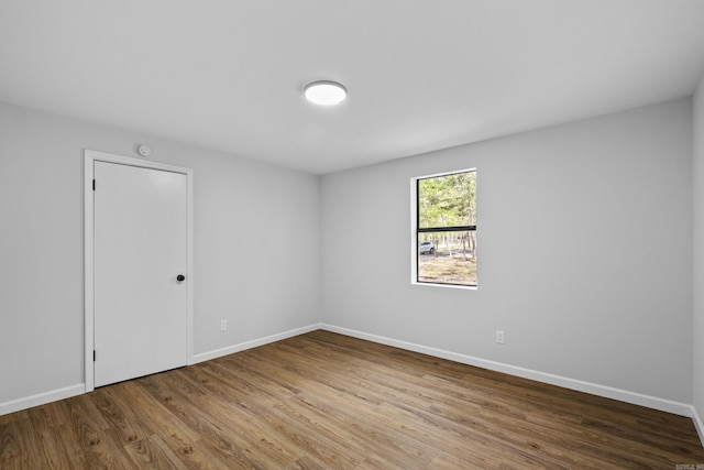spare room with wood finished floors and baseboards