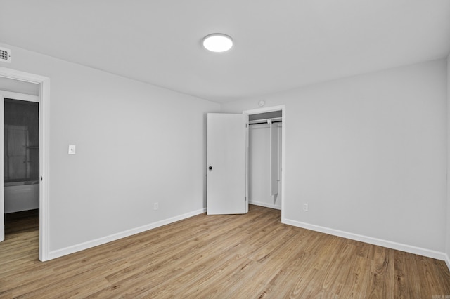 unfurnished bedroom with visible vents, baseboards, a closet, and light wood-style floors
