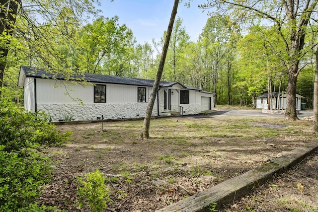 manufactured / mobile home featuring crawl space, an attached garage, and driveway