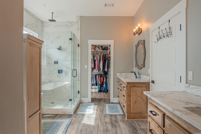 234 Barrett Ln, Cabot, AR 72023 - bathroom featuring vanity, visible vents, wood finished floors, a marble finish shower, and baseboards