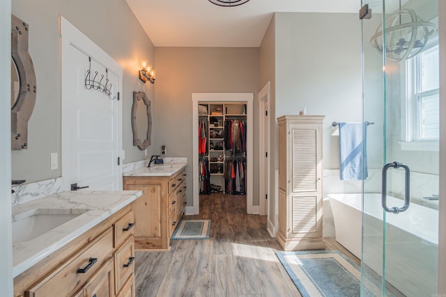 234 Barrett Ln, Cabot, AR 72023 - full bath with two vanities, a freestanding tub, a spacious closet, wood finished floors, and a sink