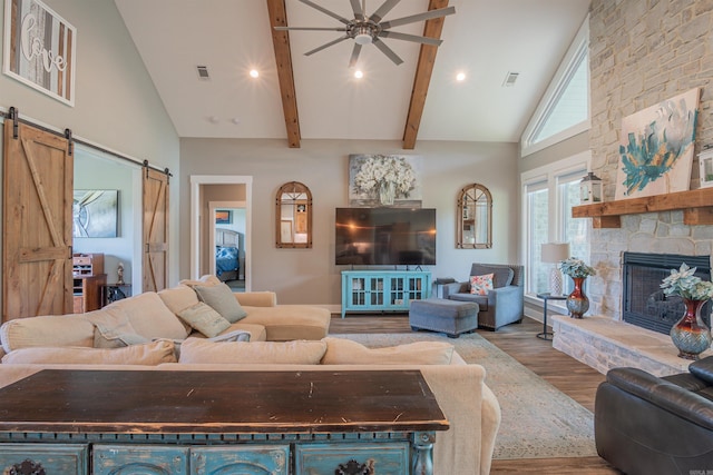 234 Barrett Ln, Cabot, AR 72023 - living room featuring visible vents, a barn door, a stone fireplace, wood finished floors, and high vaulted ceiling