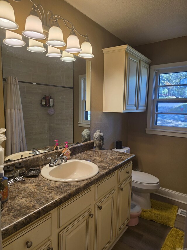 801 Randall Dr, Searcy, AR 72143 - full bathroom with a tile shower, vanity, visible vents, toilet, and wood finished floors