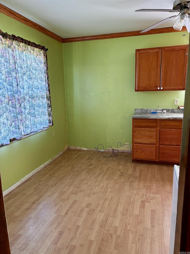 interior space with light wood-style flooring, crown molding, ceiling fan, and baseboards