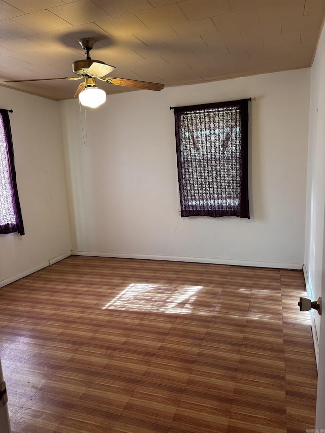 unfurnished room featuring baseboards, a ceiling fan, and wood finished floors