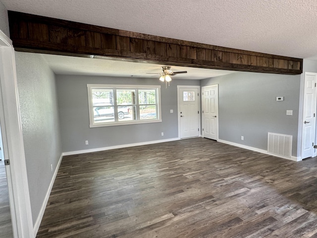 unfurnished living room featuring visible vents, a textured ceiling, a ceiling fan, and dark wood finished floors