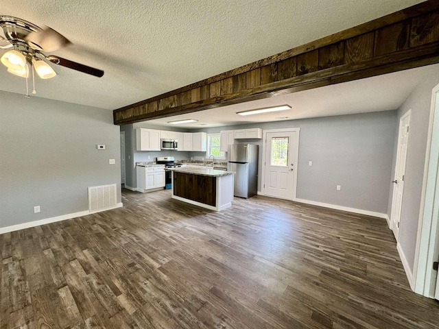 kitchen with white cabinets, open floor plan, visible vents, and appliances with stainless steel finishes