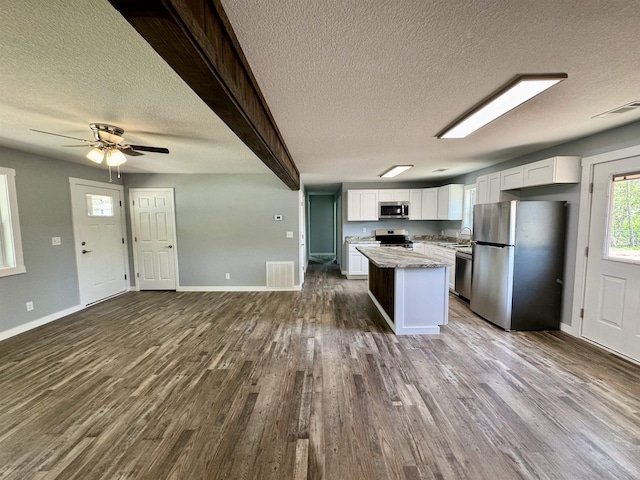 kitchen with visible vents, white cabinets, a textured ceiling, and stainless steel appliances