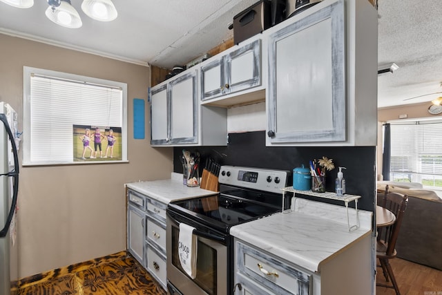 kitchen with stainless steel appliances, gray cabinets, a textured ceiling, and crown molding