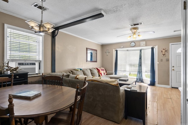 dining space featuring light wood-style flooring, visible vents, ornamental molding, and a healthy amount of sunlight