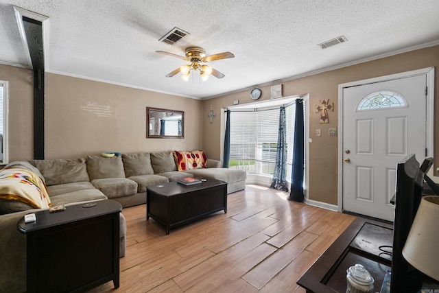 living room featuring visible vents, ceiling fan, and crown molding