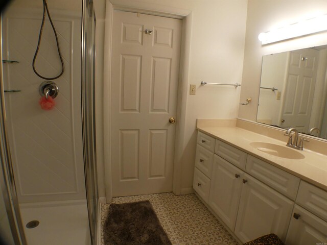 full bathroom featuring tile patterned floors, vanity, and a shower stall