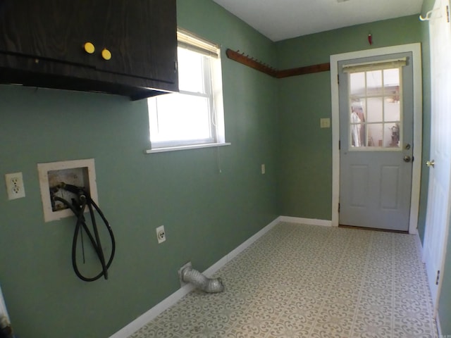 washroom with baseboards, cabinet space, and hookup for a washing machine