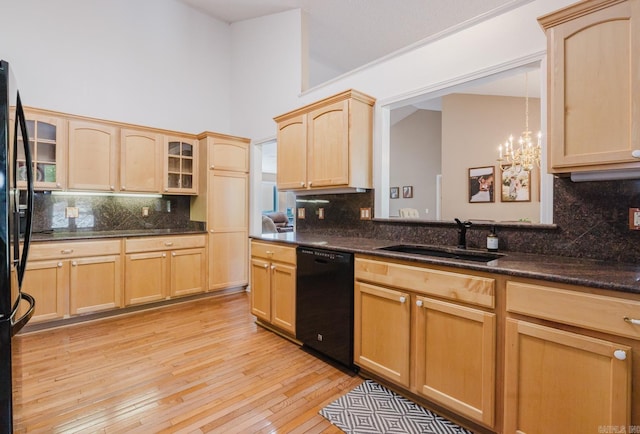 kitchen featuring black appliances, backsplash, light brown cabinetry, and a sink