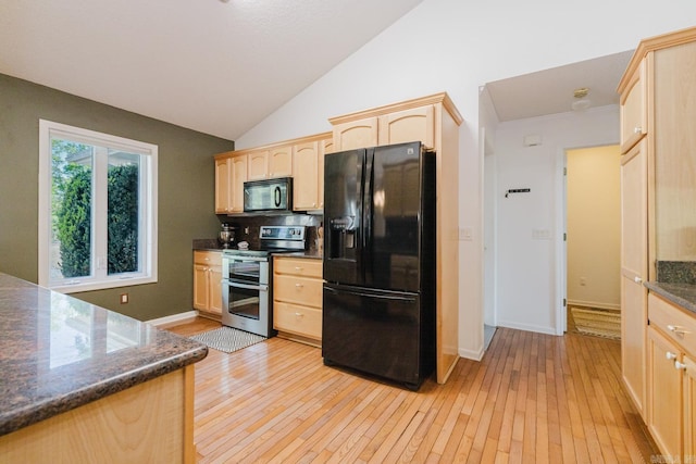 kitchen with light wood-style flooring, dark countertops, vaulted ceiling, light brown cabinets, and black appliances