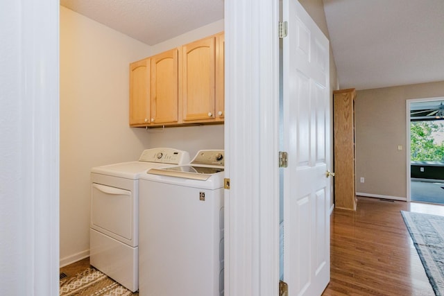 washroom with cabinet space, light wood-style floors, baseboards, and washer and dryer