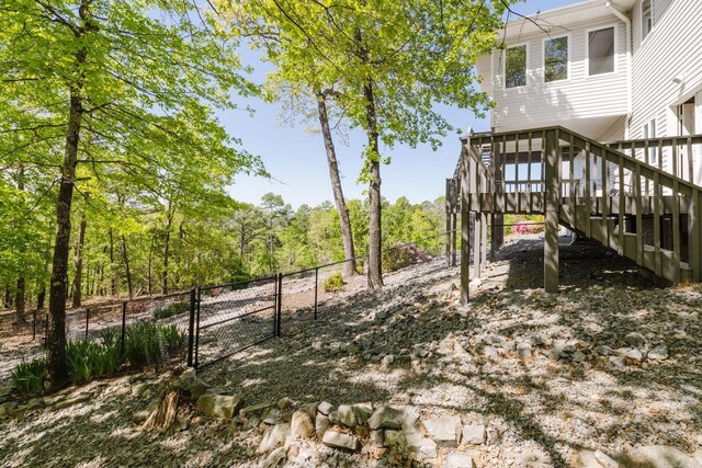 view of yard with a gate, a wooden deck, fence, and stairway