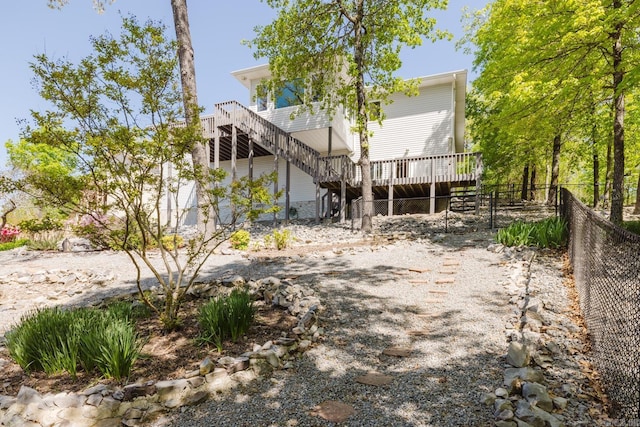 rear view of house with a wooden deck, stairway, and fence