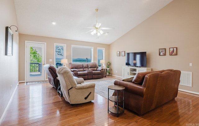 living room featuring hardwood / wood-style floors, visible vents, baseboards, and ceiling fan