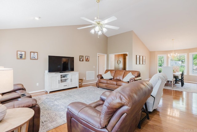 living area featuring visible vents, light wood finished floors, baseboards, and ceiling fan with notable chandelier