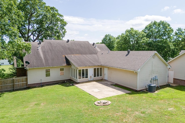 back of property featuring central AC unit, fence, a patio area, a shingled roof, and a yard