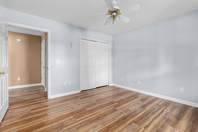 unfurnished bedroom with ceiling fan, baseboards, a closet, and light wood-type flooring