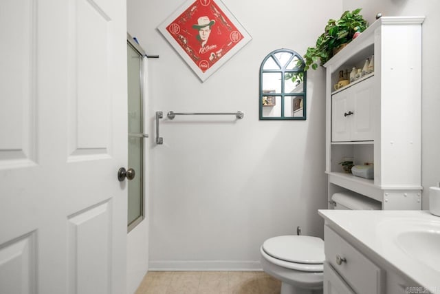 bathroom featuring baseboards, vanity, tile patterned floors, and toilet